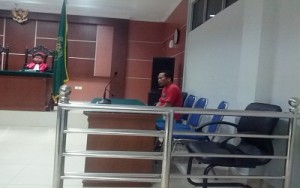 terdakwa panjaitan sedang duduk mengikuti sidang mendengarkan keterangan saksi dan korban. foto (potretkepri.com)
