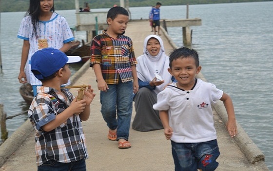 Dermaga - sejumlah anak-anak kecil , dengan didampingi seorang wanita dewasa bermain di dermaga. foto / Mulkan Kautsar. (potretkepri.com)